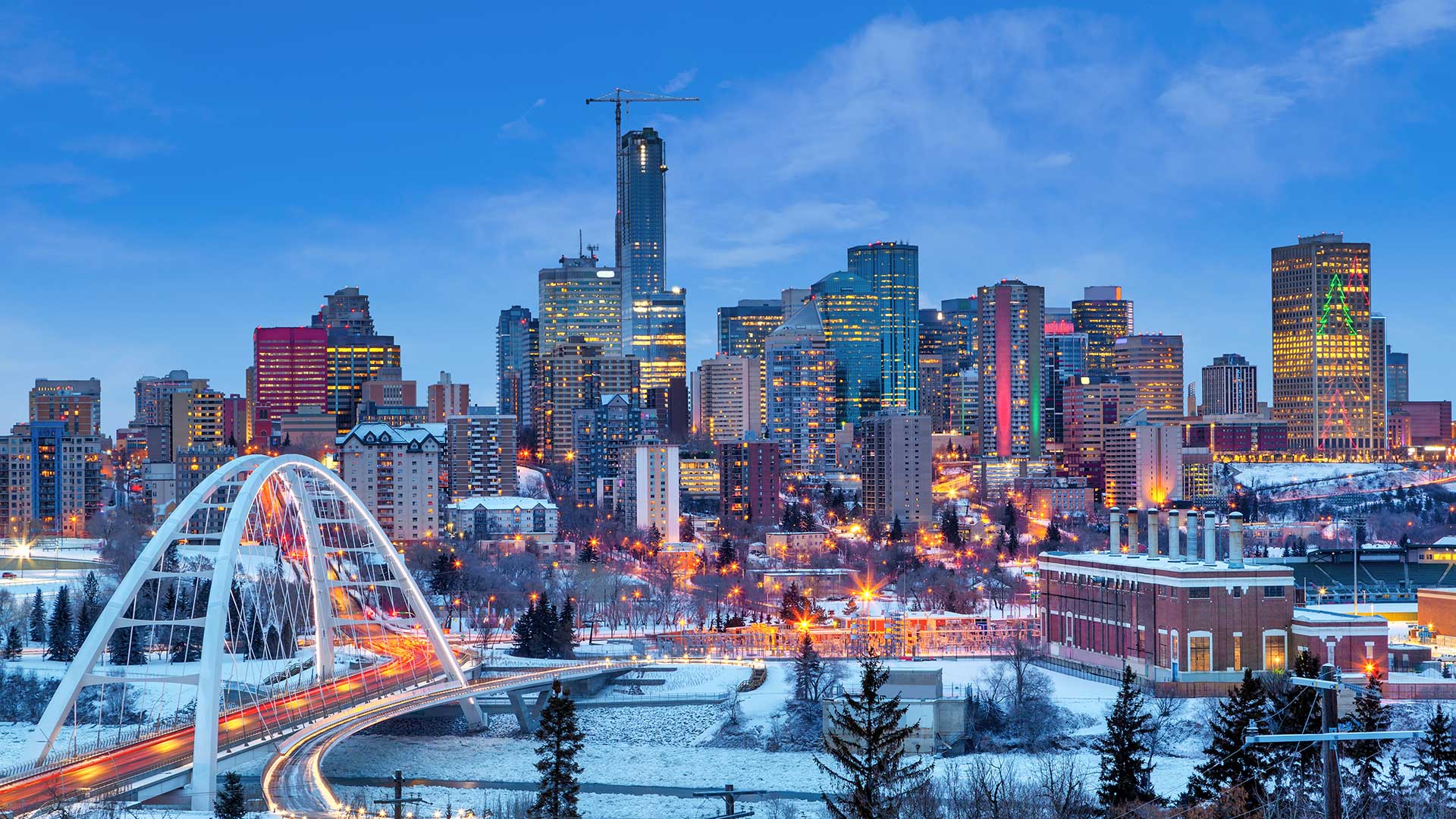 Edmonton skyline at dusk with illuminated city buildings.