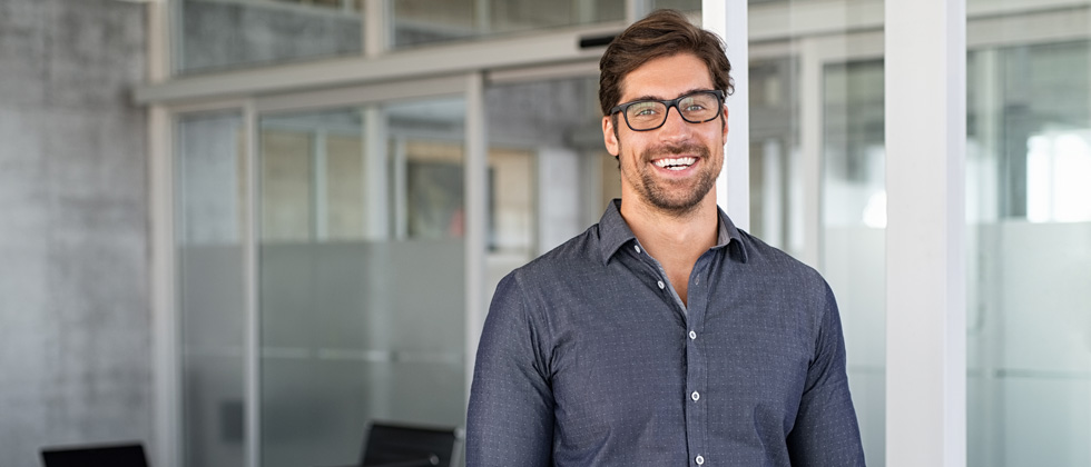 Handsome guy wearing glasses standing in a corporate office