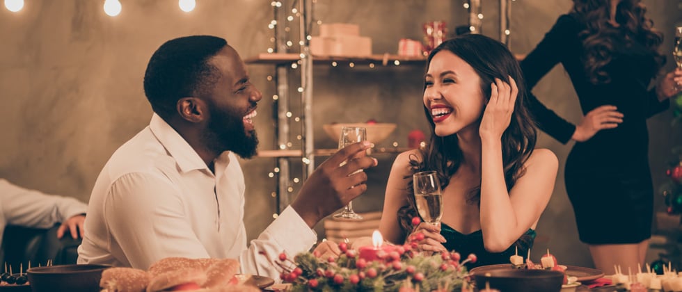 A couple on a date laughing and drinking champagne