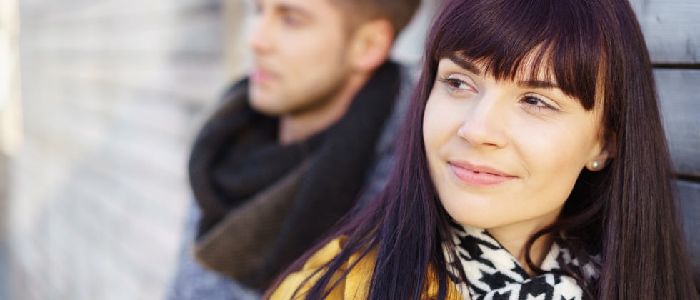 A couple standing together with the woman smiling into the camera's focus