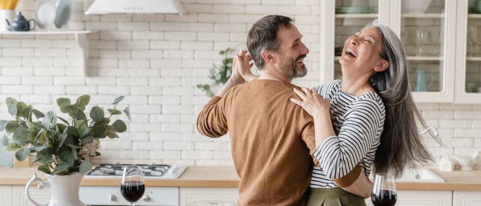 Couple dancing in the kitchen laughing