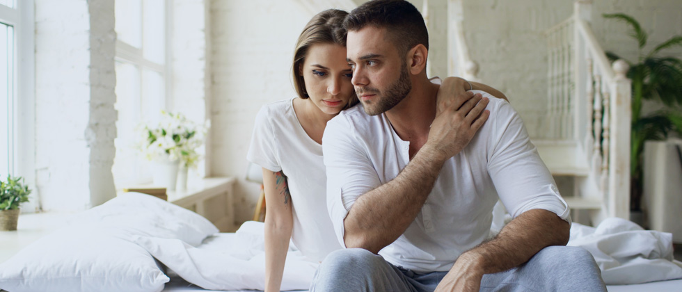 A couple holding each other looking overcome with grief