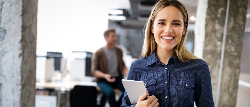 A woman standing with an iPad in a corporate office