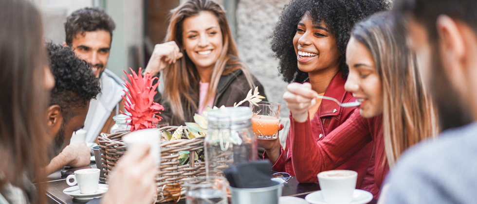 A group of young friends having fun talking and eating over brunch