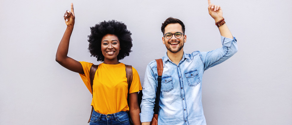 Man & woman standing holding hands and holding their other hands up