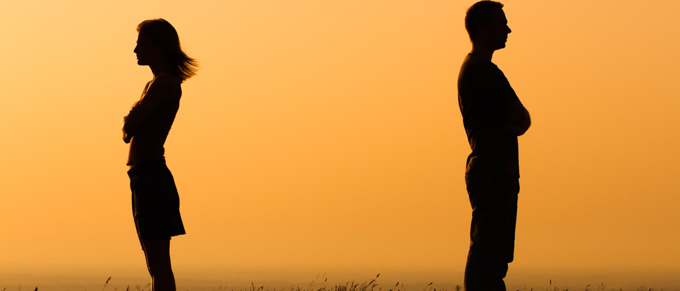 Couple with their backs turned away from each other & arms crossed