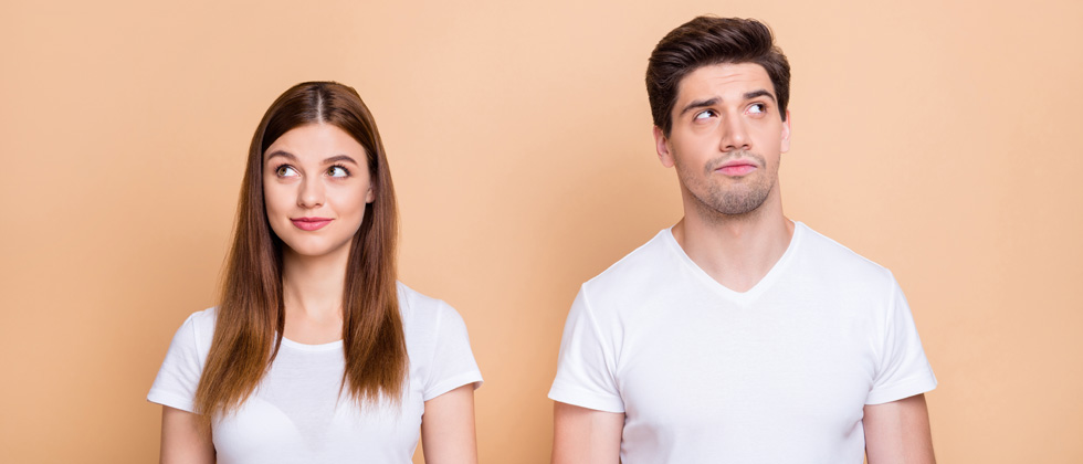 Couple next to each other looking in opposite directions smiling