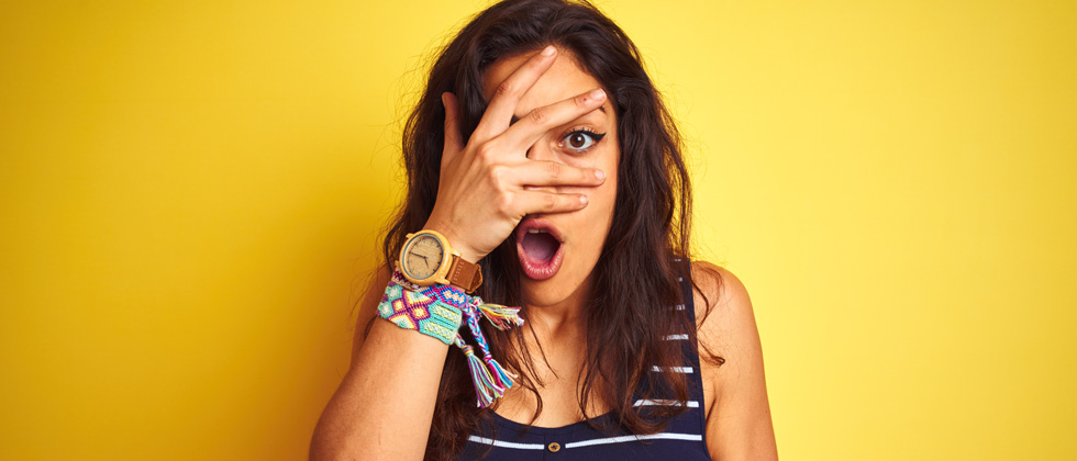 Girl in shock covering her face trying to hide from embarrassment