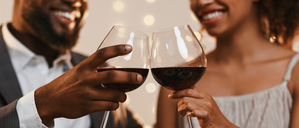 A couple cheering over red wine and smiles