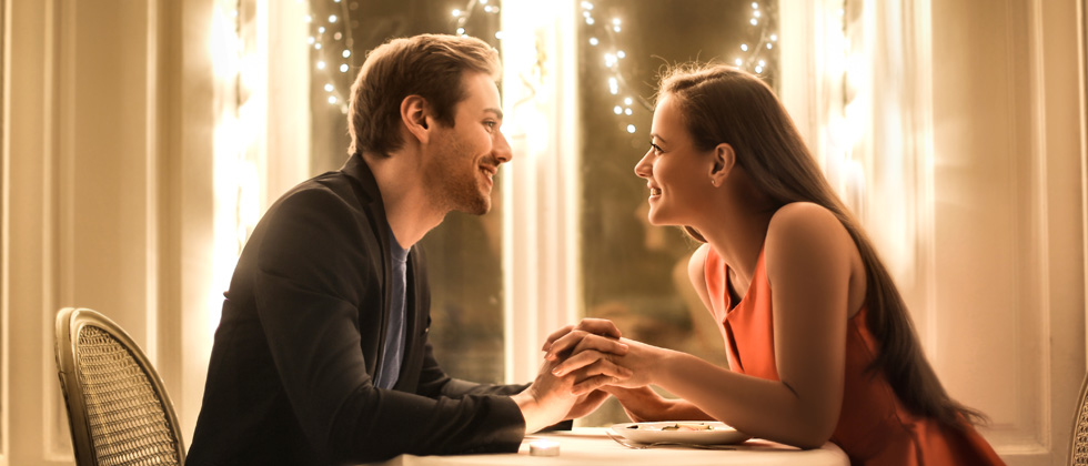 Couple lovingly holding hands on a romantic dinner date