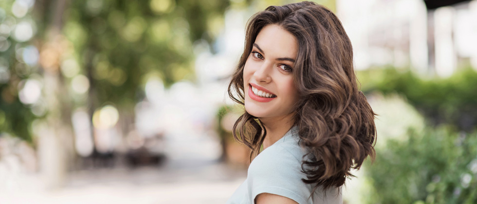 A woman walking and looking back while making eye contact with the camera