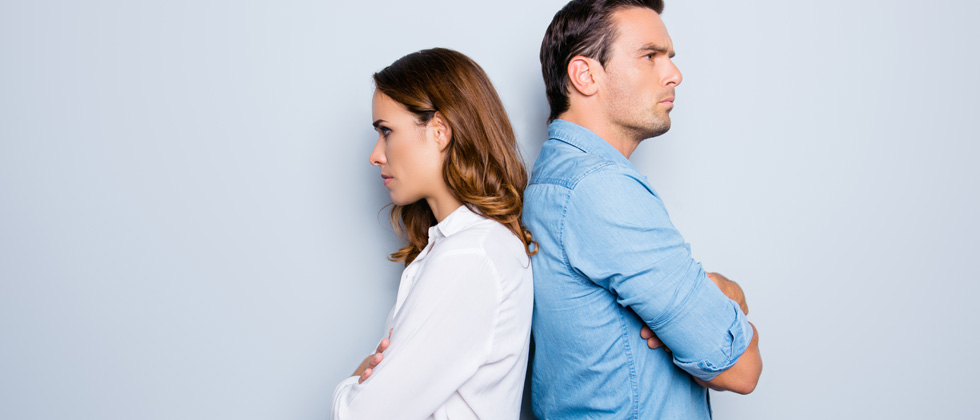 Couple standing back to back while they have a disagreement