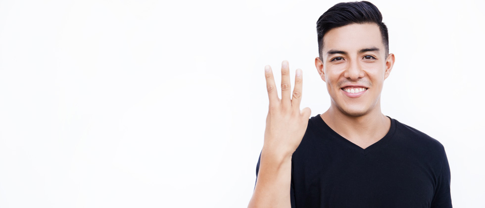 Young guy in a black shirt holding up 3 fingers