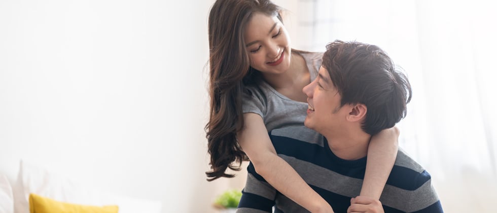 Someone holding onto their partner's back as they look at each other