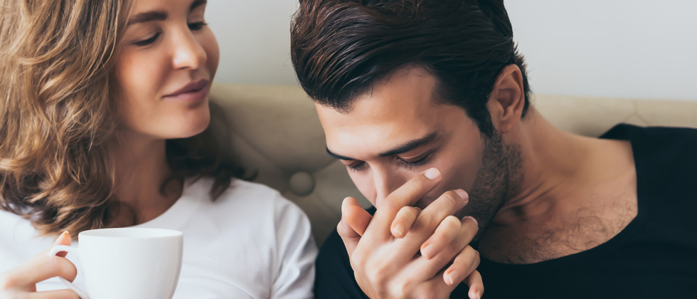 Couple holding hands and man kissing her hand in his