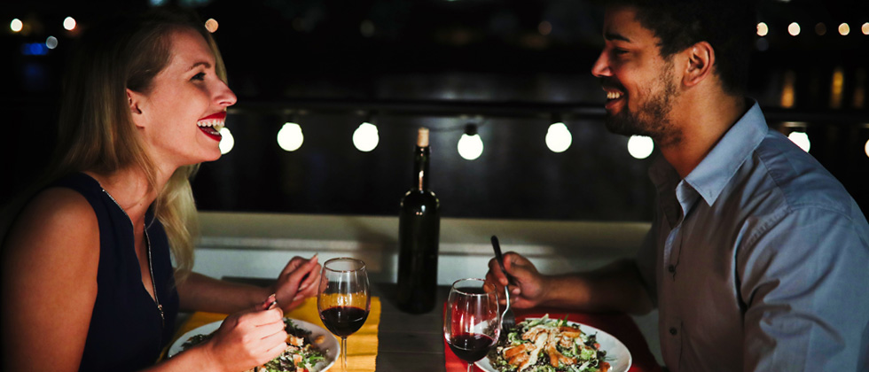 Young couple laughing while on a dinner date at a restaurant