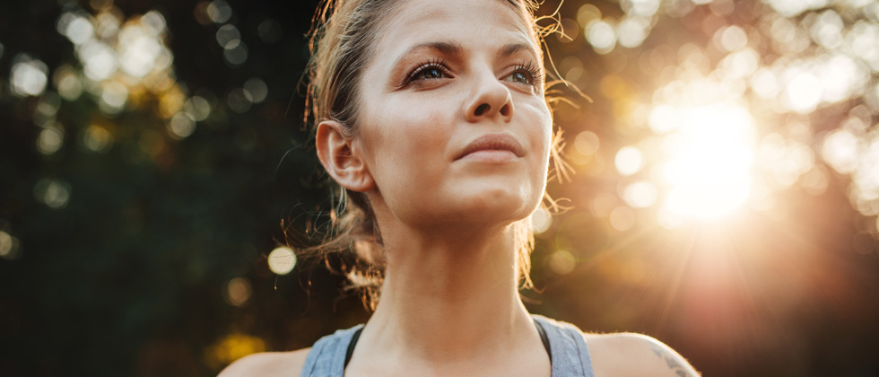 A woman looking serious about to go for a run in the sunshine