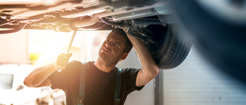 A male mechanic working on a car in a garage