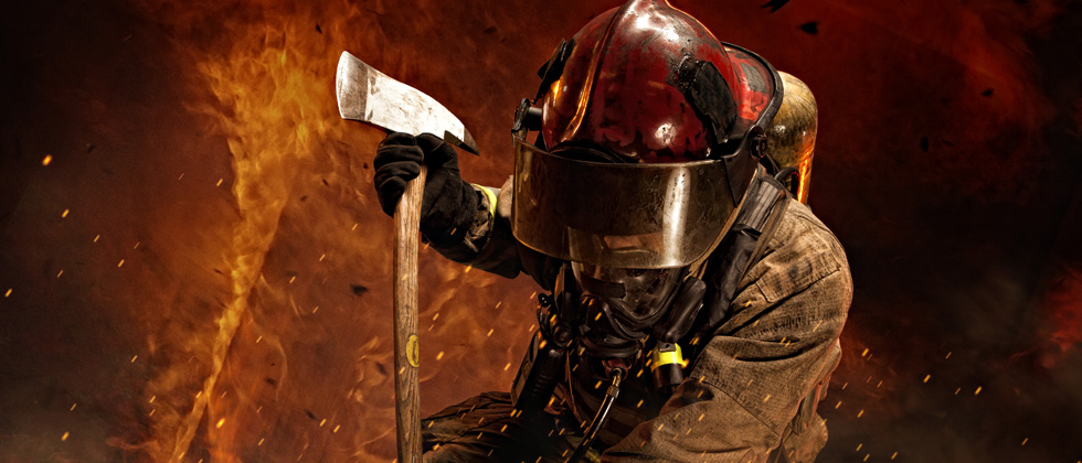 A firefighter intensely battling a large fire