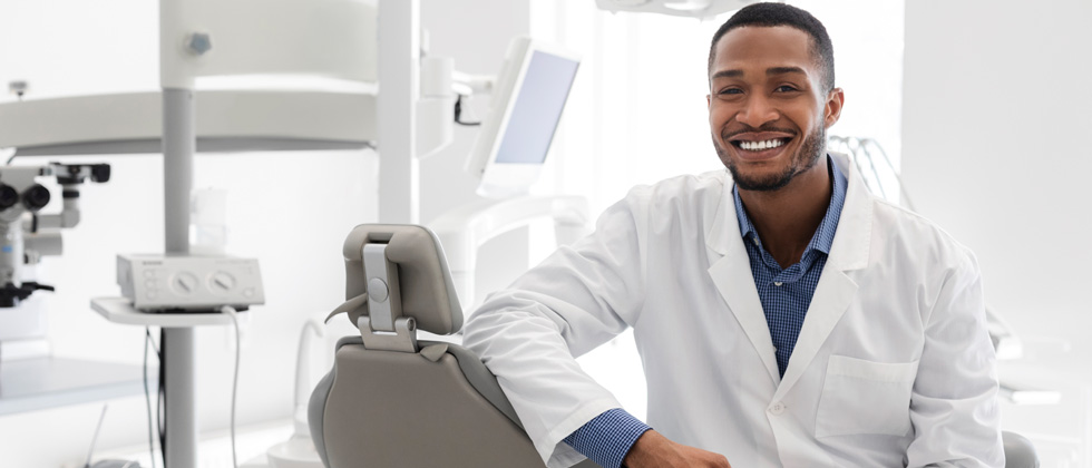 A male dentist sitting in his dental office chair
