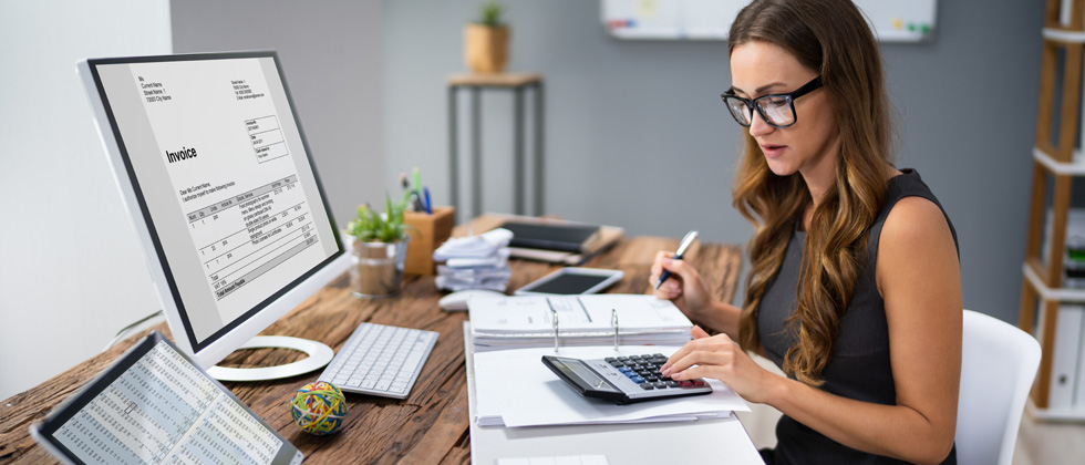 A female accountant sitting at her computer with an invoice