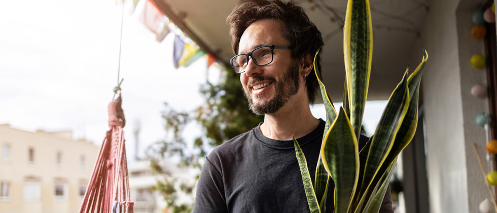 A guy in glasses standing on his front porch smiling