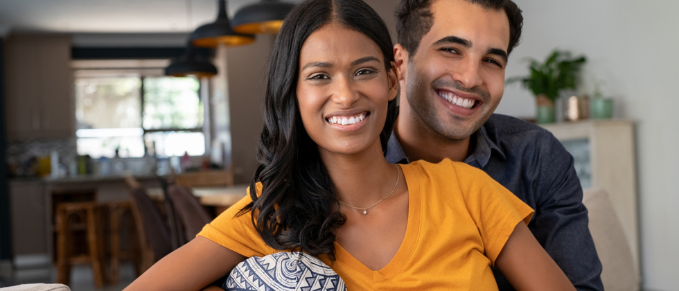 A couple sitting together and smiling for the camera