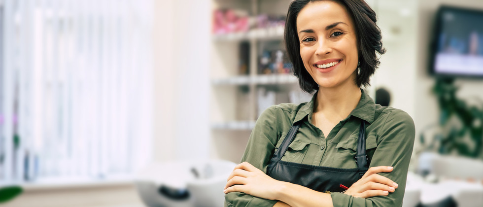 A female hairdresser standing in her salon with her smock on
