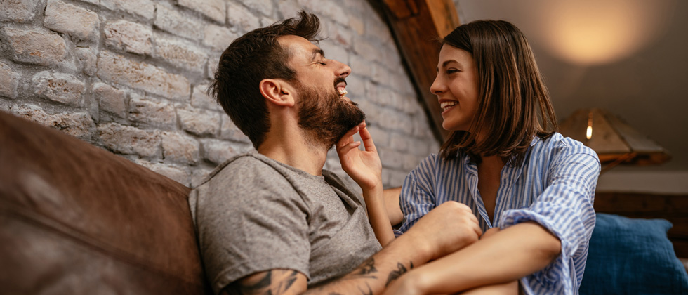 A couple sitting together - woman touching his face gently