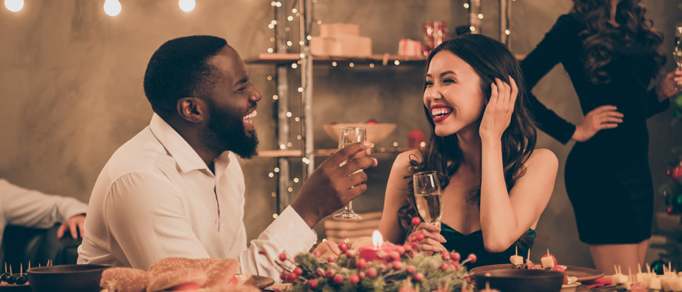 A couple on a date laughing and drinking champagne
