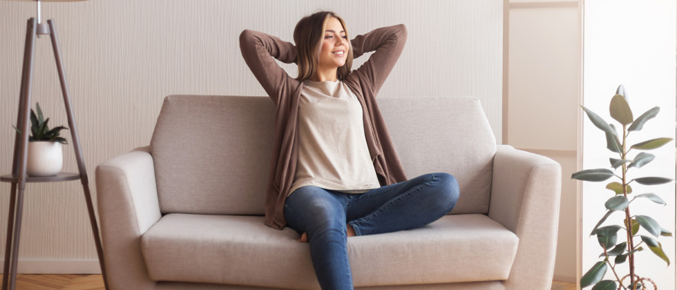 A woman sitting on the couch getting ready to relax