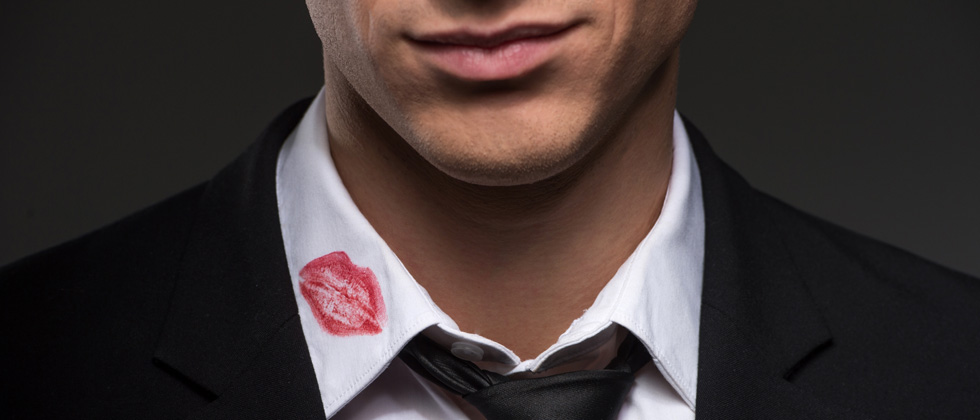 A guy with a big red lipstick stain on the collar of his shirt
