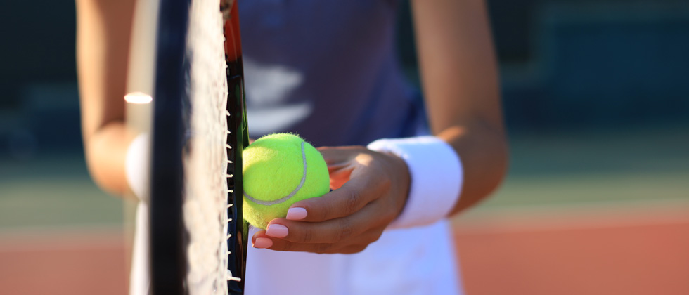 A woman on a tennis court getting ready to serve