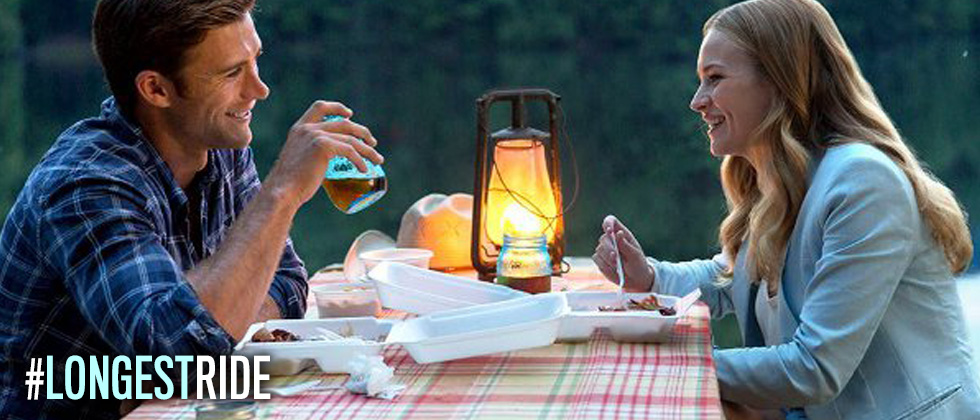 A couple having a picnic in the middle of the woods by candlelight