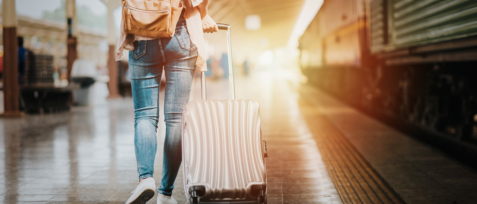 Someone walking through a train station rolling a suitcase