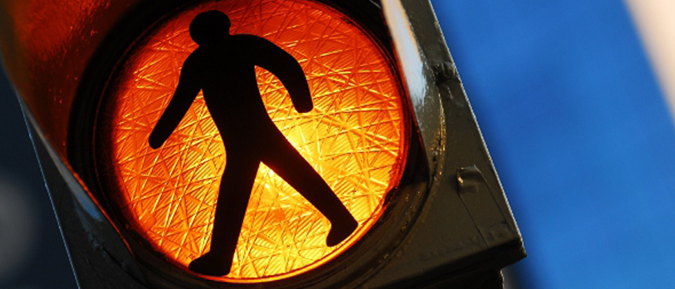 A pedestrian walk symbol showing for people to slow