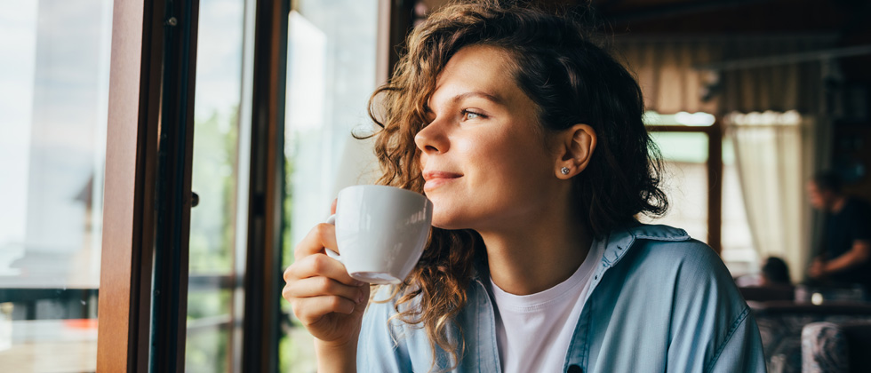 A woman smiling and looking in the distance smiling