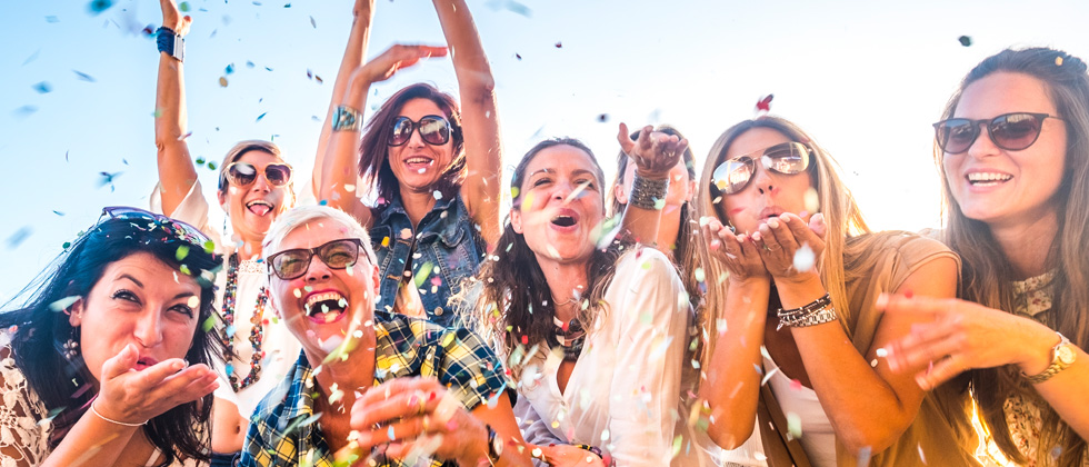 A group of people having fun at a party & throwing confetti