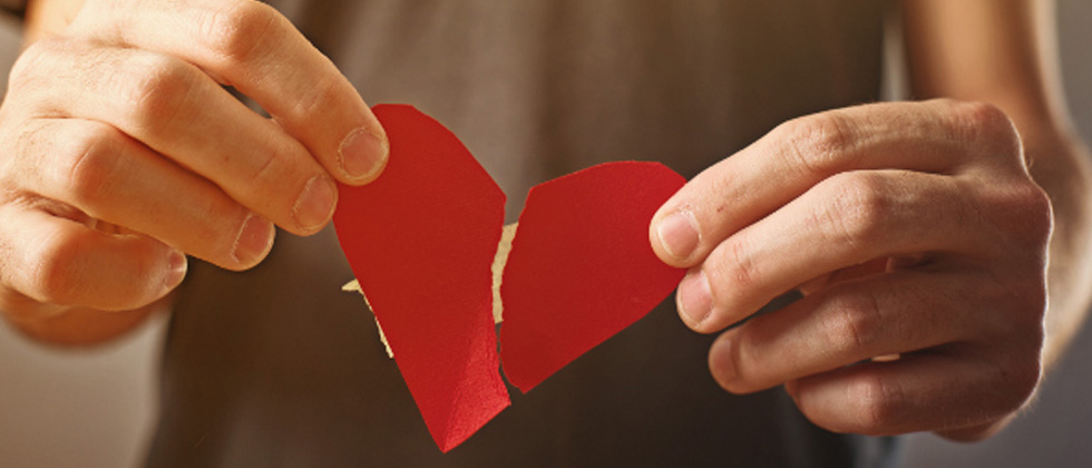 A riped paper heart that's being mended with tape