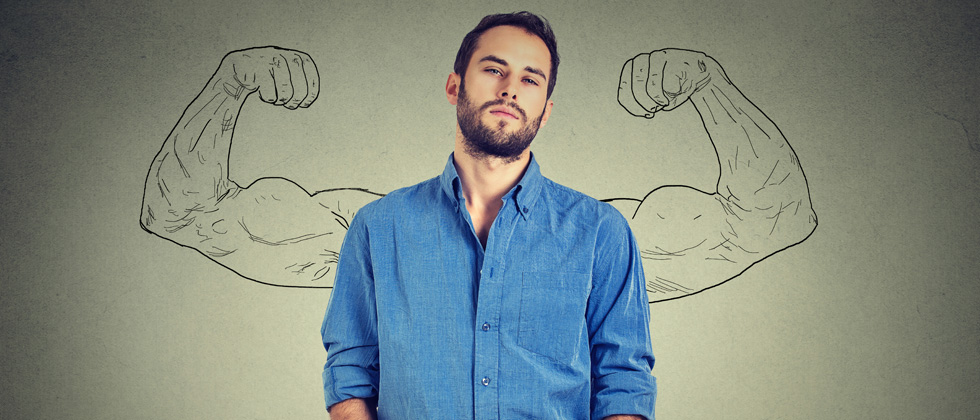 A man standing Infront of a mural of a guy showing off his muscular arms