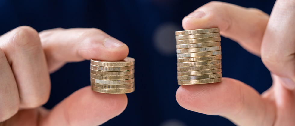 Someone holding two stacks of coins - one bigger than the other