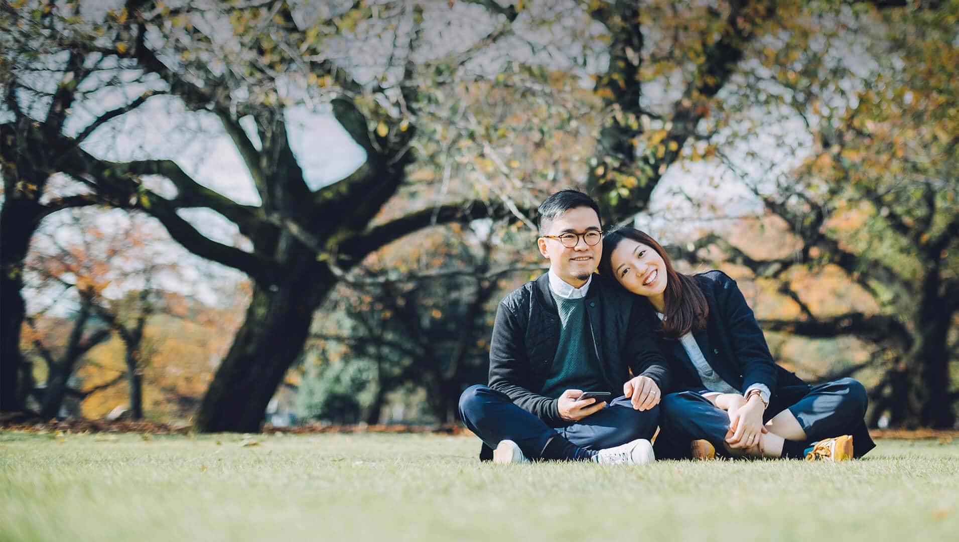 Japanese dating symbolized by a man and woman sitting cross-legged next to each other on a green field in Canada