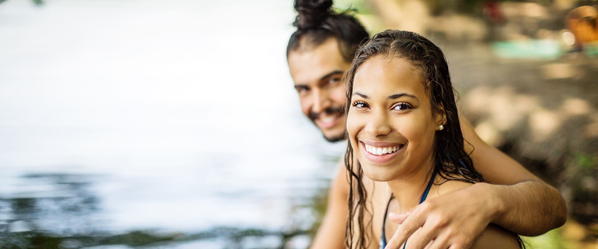 Hispanic couple hugs and smiles at the camera