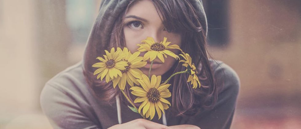 Sad woman holding a bouquet of wilting flowers