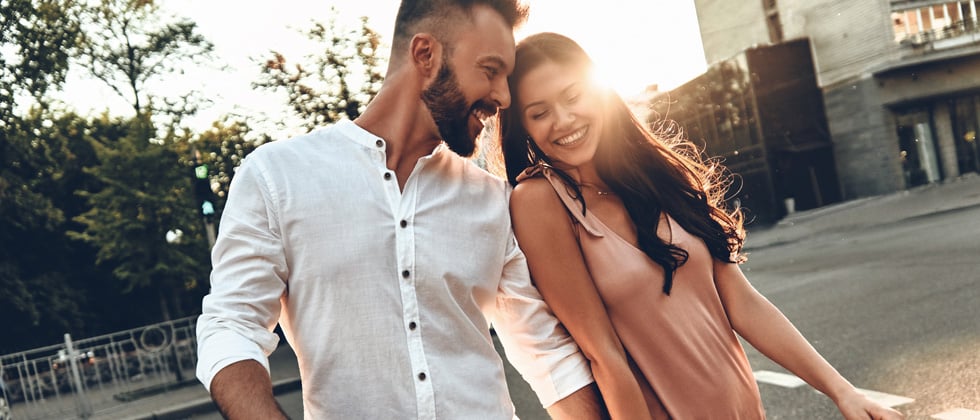 Couple leaning on each other, laughing & holding hands