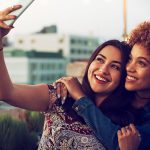 Lesbian dating illustrated by a happy couple doing a seflie after finding each other on a lesbian dating site