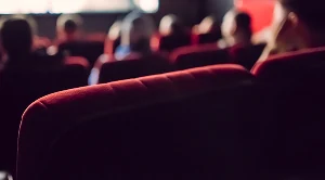 A row of red movie theatre seats.