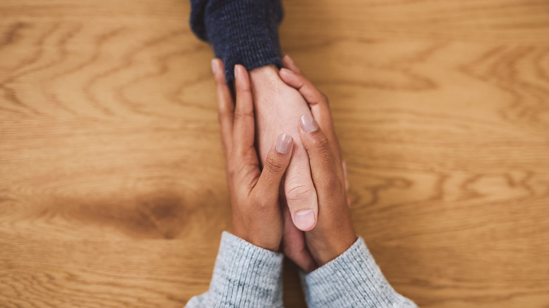 Two people holding hands. Only the hands are visible.