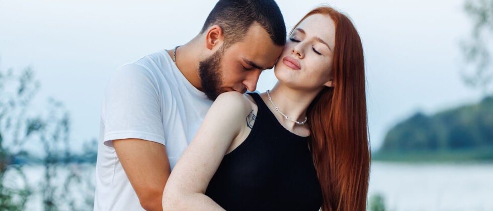 Man kisses woman on shoulder as symbol of being vulnerable