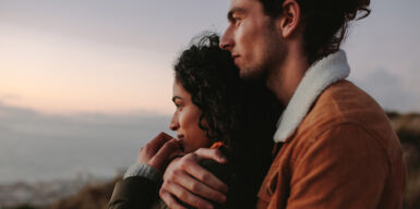 Man and woman lie in arms with view of mountains as symbol of fairytale love